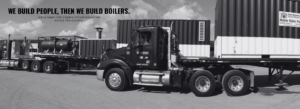 Black-and-white photo of a tractor-trailer carrying large industrial equipment with the bold banner: 'We build people, then we build boilers' inviting joining the team.