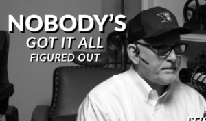 Podcast cover: grayscale image of a man with glasses and a headset in a studio, bold title 'NOBODY'S GOT IT ALL FIGURED OUT'