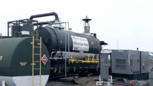 Mobile boiler plant on a trailer with yellow pipelines and a large green cylindrical boiler, ready for temporary steam generation at an industrial site