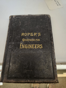 Worn leather-bound book with gold lettering: 'Roper's Questions for Engineers'.