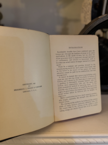Open book on a desk with the right page titled 'INTRODUCTION' and dense text.
