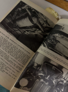 Open vintage car manual showing black-and-white engine photograph and a classic Packard automobile illustration on adjacent page, text blocks visible on the left page.