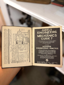 Open vintage engineering manual showing a detailed mechanical diagram on the left and the Audels Engineers and Mechanics 7 title page on the right.