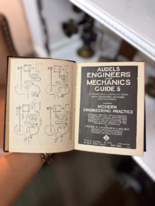 Open vintage engineering book showing diagrams on the left and the title page 'Audels Engineers and Mechanics Guide 5' on the right.