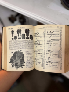Open vintage technical manual showing schematic diagrams on both pages, including a large circular mechanical component on the left page.