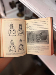 Open vintage engineering book displaying four gas engine diagrams on the left page and a labeled internal-parts image on the right page.