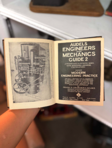 Open vintage engineering book showing machinery illustration on left and 'Audels Engineers and Mechanics Guide 2' cover on right.
