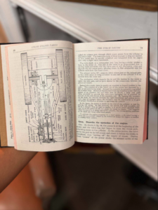 Open manual showing a detailed diagram of steam engine parts on the left page and explanatory text on the right page.