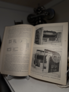 Open technical manual showing diagrams of machinery and a boiler with labeled components on the right page.