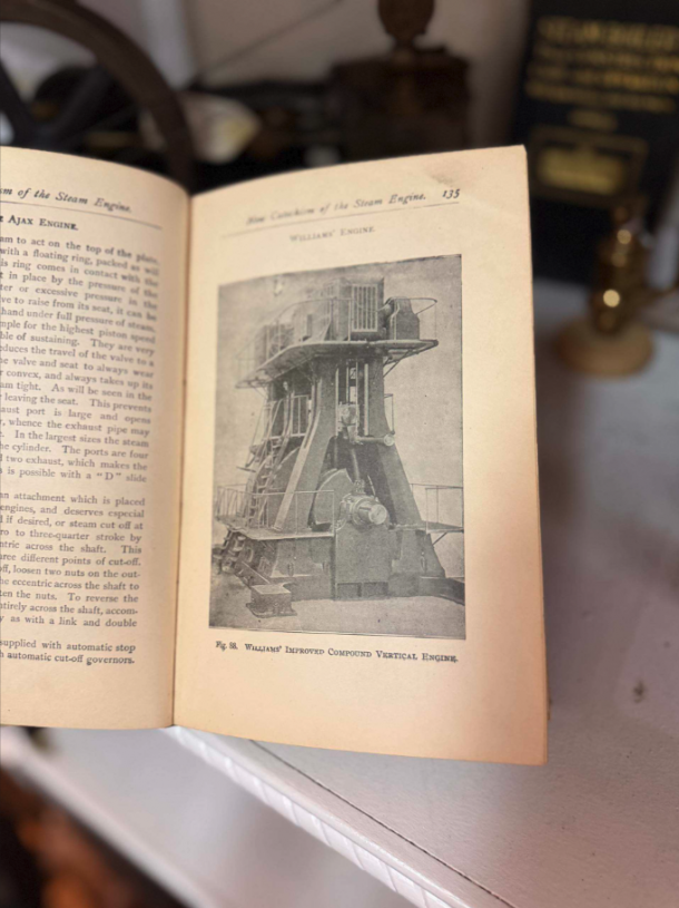 Open vintage book showing a black-and-white illustration of a vertical steam engine, captioned “William’s Improved Compound Vertical Engine.”