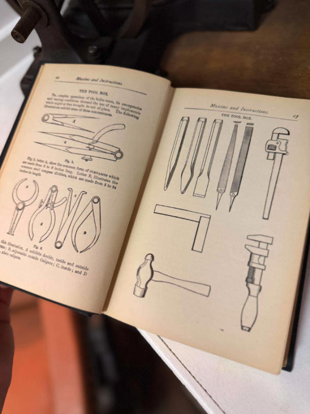 Open instruction manual showing black-and-white diagrams of hand tools (pliers, pincers, calipers) across two pages, with a hammer and chisels on the right page, held by a person.